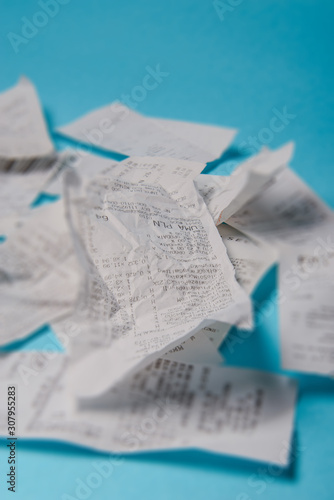 Pile of shopping receipts on blue background
