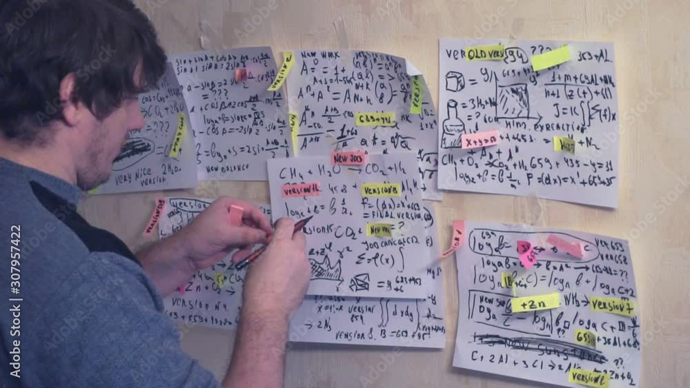 researcher works with various information on paper sheets that hang on the wall.research work. scientist in the workplace researcher works with various information on paper sheets that hang on the wall.research work. scientist in the workplace