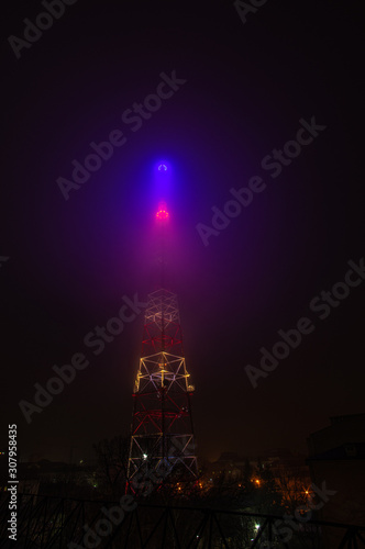 TV tower in the fog in the night city