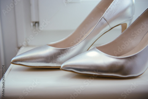 The bride shows white wedding shoes. Wedding detail. Close up.
