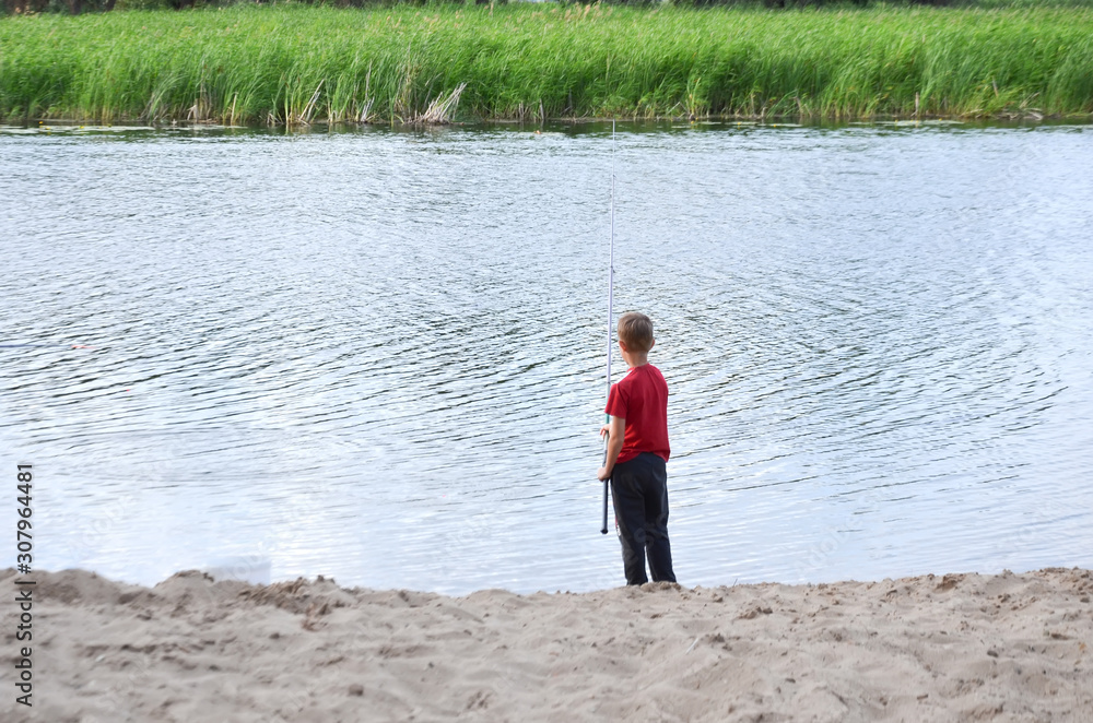the boy is fishing by the river in summer, selective the boy is fishing by the river in summer, selective