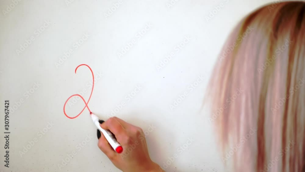A lady is writing the year approaching on the whiteboard - close up
A lady is writing the year approaching on the whiteboard - close up