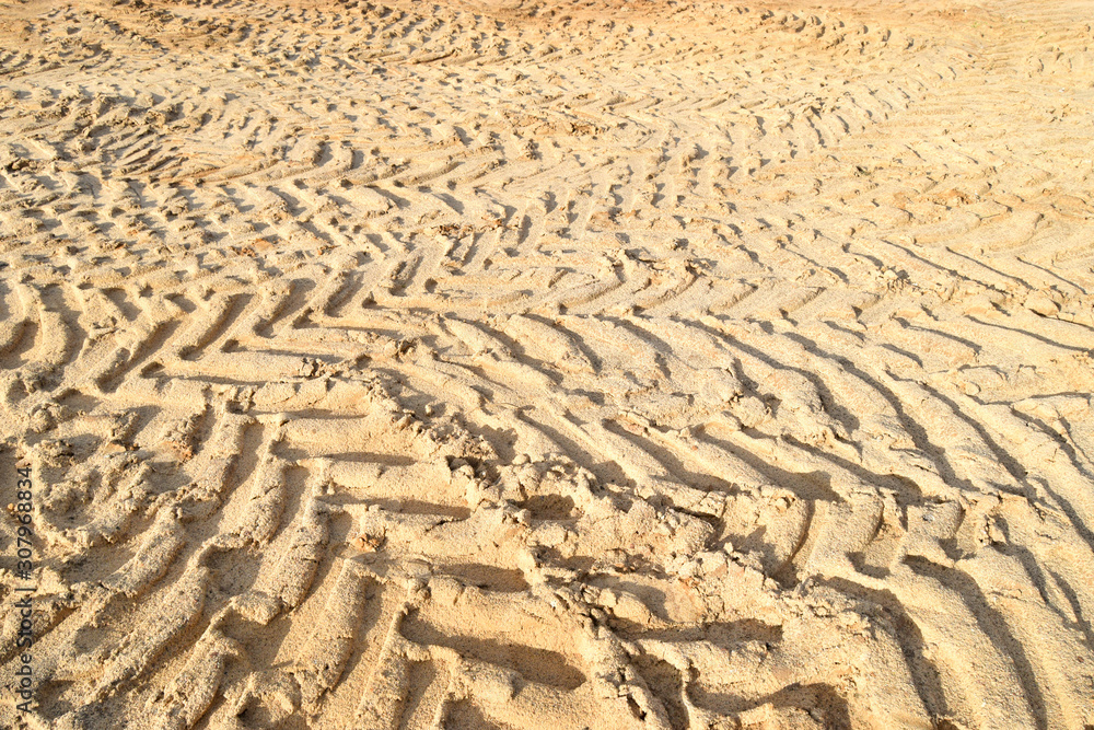 Traces from the tread of the tractor tires on the sand quarry for the extraction of sand and clay. Texture on the sand.