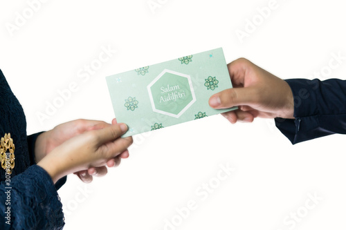 Adult man and woman hand holding money envelope known as Duit Raya in Malaysia culture. Isolated in white. Raya festive concept.