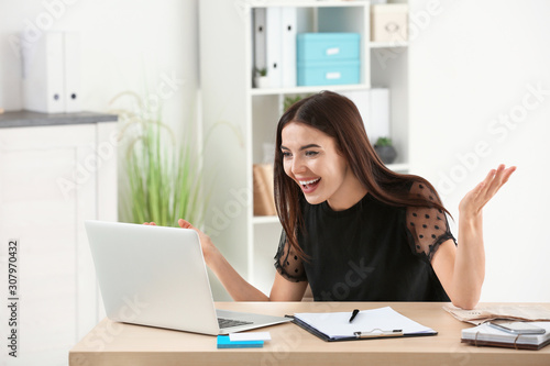 Happy young businesswoman working in office