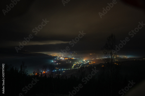 Night city in the fog in the mountains in autumn