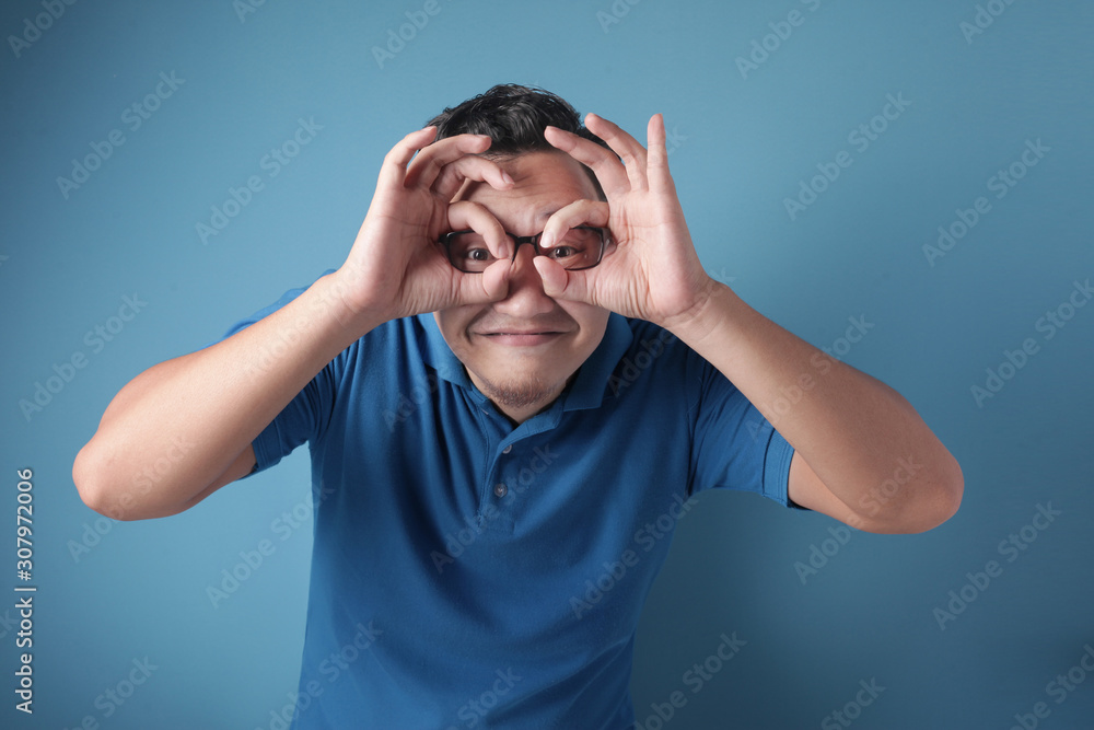 Young Man Making Telescope Gesture With His Hand Young Man Making Telescope Gesture With His Hand