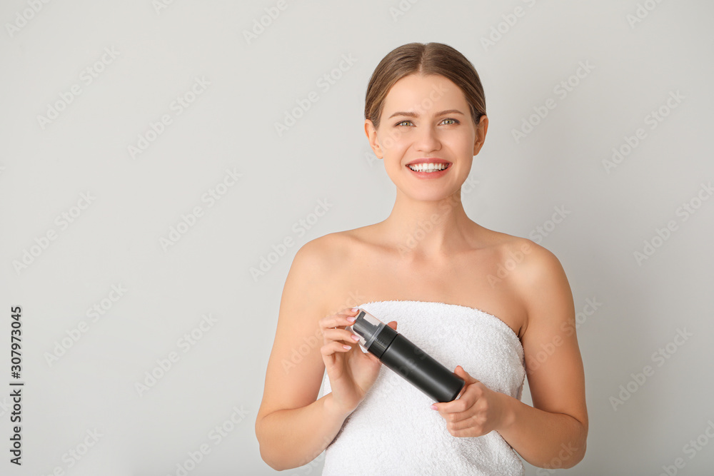 Beautiful young woman with cosmetic product on light background Beautiful young woman with cosmetic product on light background