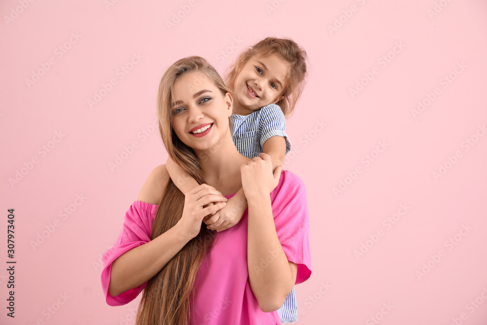 Happy woman and her little daughter on color background Happy woman and her little daughter on color background