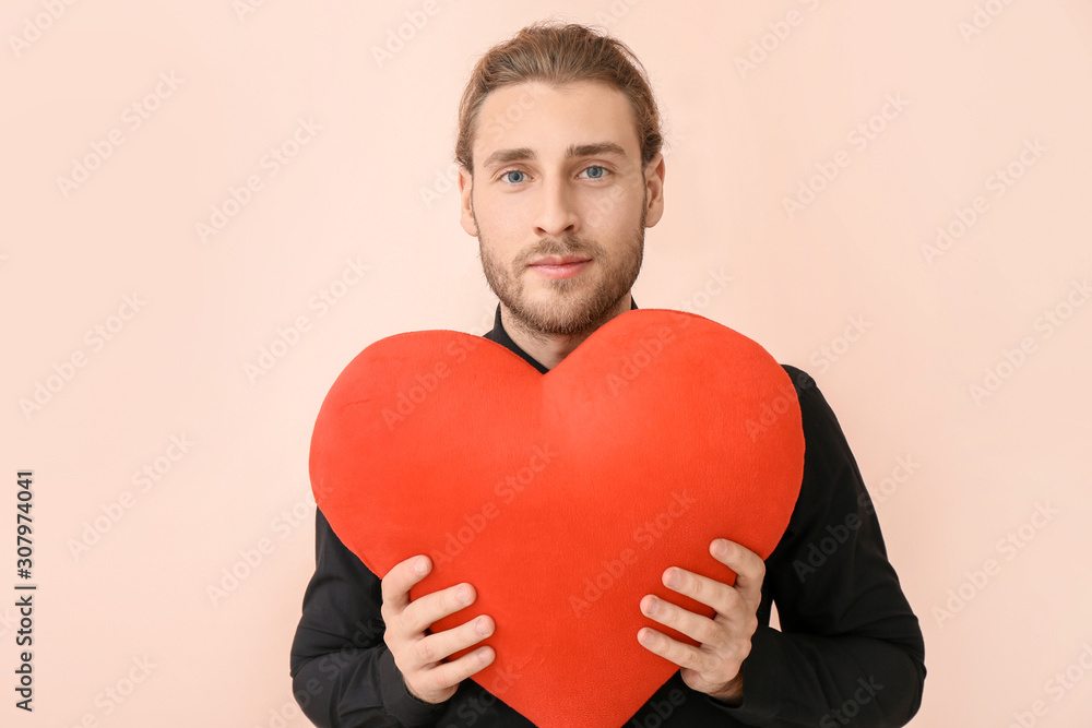 Handsome man with red heart on color background. Valentine's Day celebration Handsome man with red heart on color background. Valentine's Day celebration