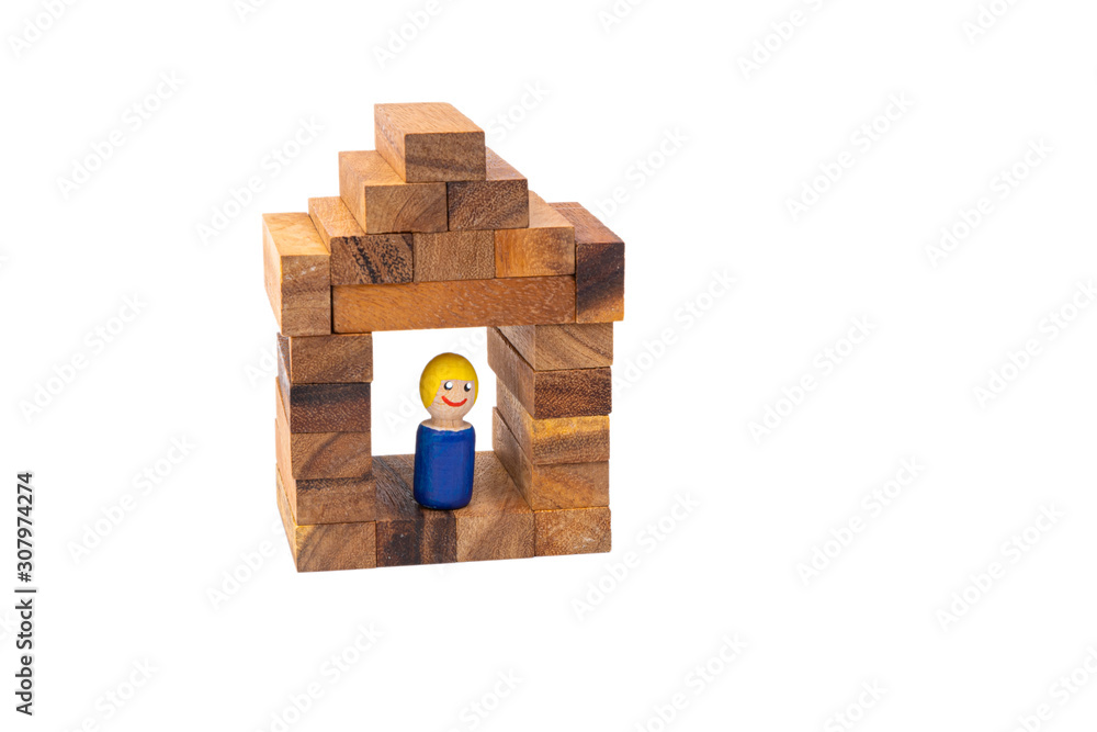 Obraz premium A wooden toy of a man stands and smiles in his beautiful wooden house on a white isolated background. The concept of a lonely happy man in a separate house.