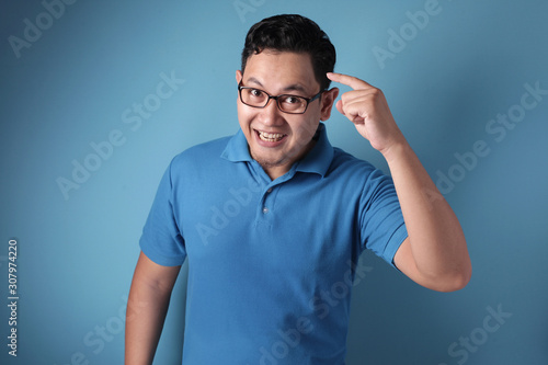 Smart Asian Man Pointing on His Head and Smile photo
