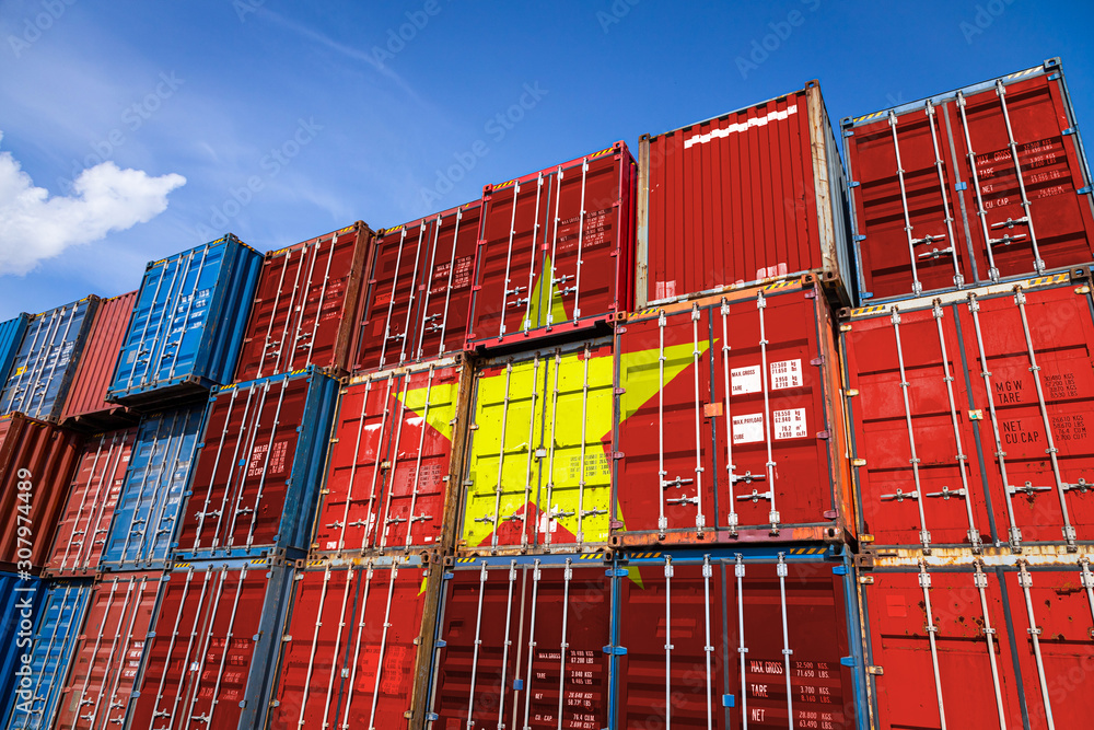 Fototapeta premium The national flag of Vietnam on a large number of metal containers for storing goods stacked in rows on top of each other. Conception of storage of goods by importers, exporters