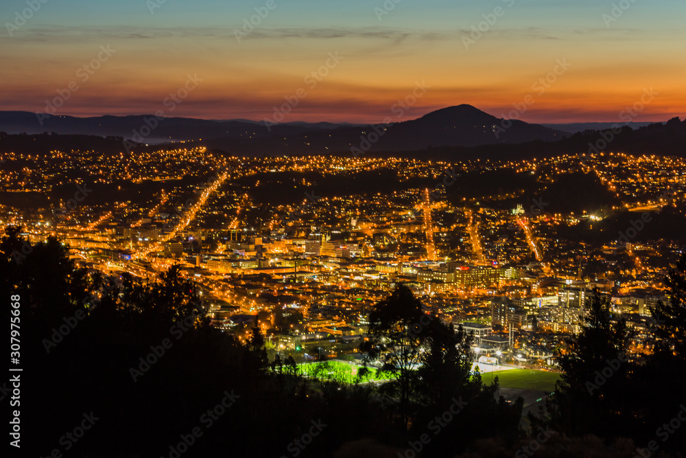 ニュージーランド　ダニーデンのシグナル・ヒル・ルックアウトから見える夕焼けに染まった空とダニーデンの夜景