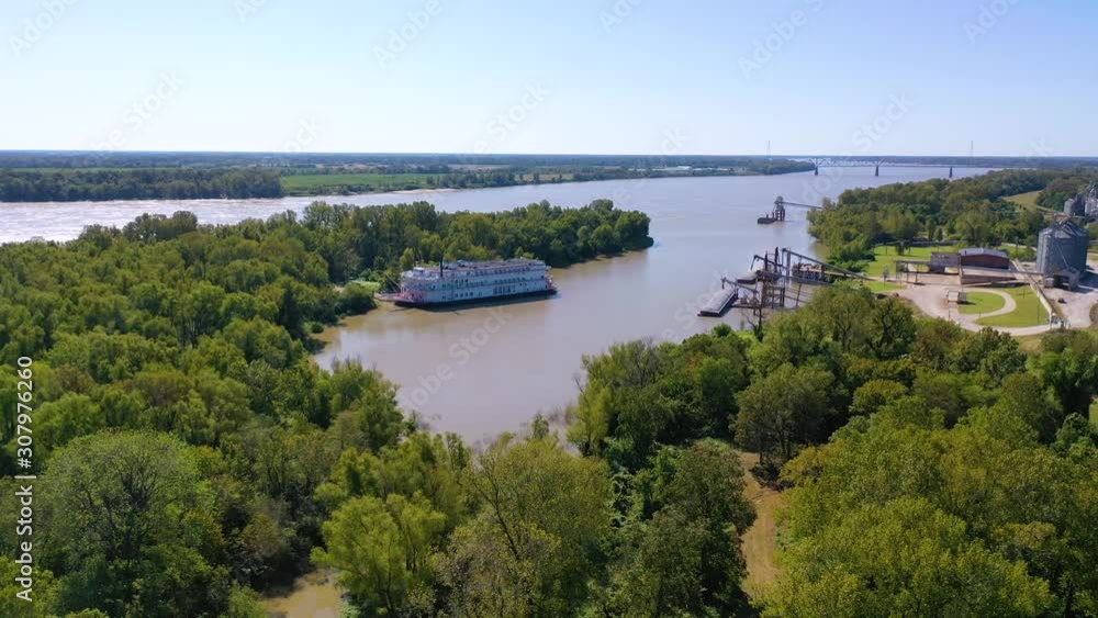 Aerial shot of a paddlewheel steamboat luxury cruise ship docked in a bay on the Mississippi River. Aerial shot of a paddlewheel steamboat luxury cruise ship docked in a bay on the Mississippi River.