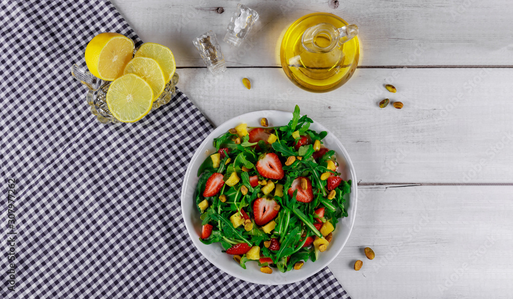 Salad with arugula, strawberries and mango with olive oil and lemon. Salad with arugula, strawberries and mango with olive oil and lemon.