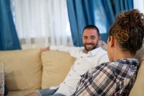 girl sitting on a couch with a boy on the side out of focus