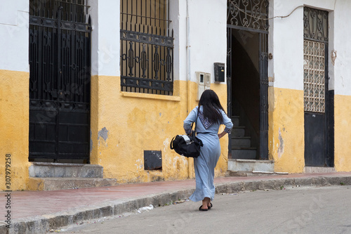 Unknown young woman walking on the street in the historical part of Tangier, Northern Morocco.