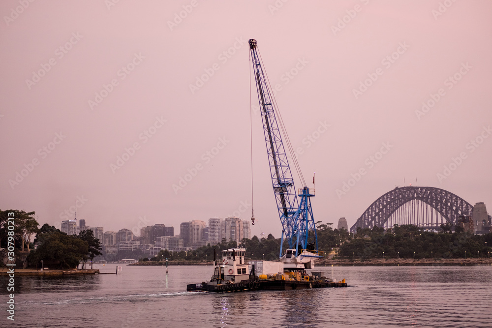 Fototapeta premium Crane being pushed by a tugboat