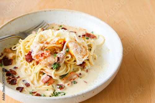 Pasta cream sauce with bacon and poached egg