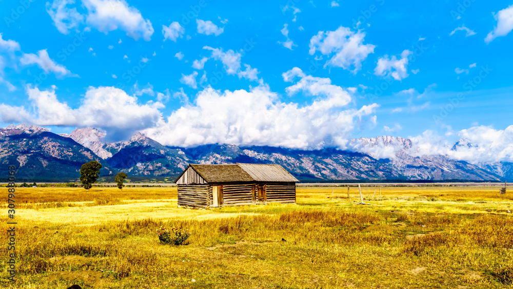 Obraz premium An abandoned Barn at Mormon Row with in the background cloud covered Peaks of the Grand Tetons In Grand Tetons National Park near Jackson Hole, Wyoming, United States