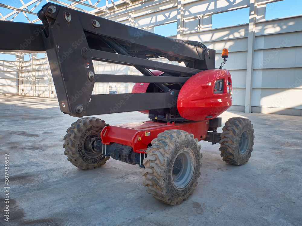 Obraz premium Red man lifting platform machinery at construction site
