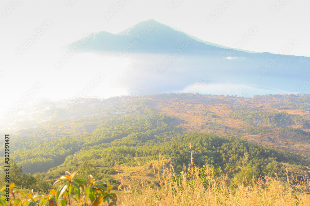 Fototapeta premium beautiful sunrise with fog and landscape view with Batur Mountain Background, Kintamani, Bali, Indonesia