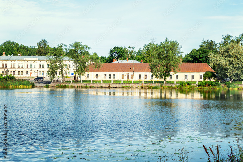 Obraz premium Beautiful historic buildings by the river in Vyborg on a bright sunny day.