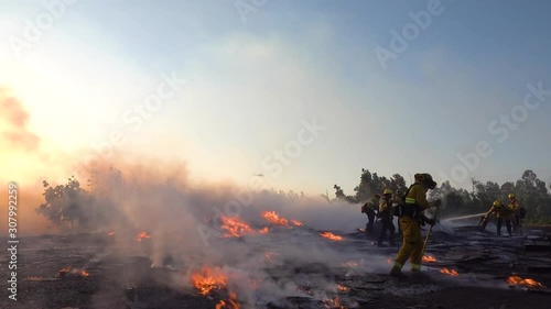 2019 - ground fire burns as firefighters battle a burning structure during the Easy Fire wildfire disaster in the hills near Simi Valley Southern California. photo
