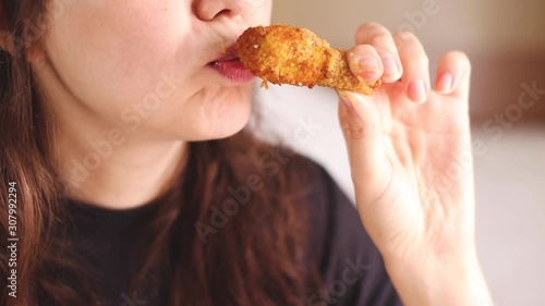 young pretty woman eating chicken wings