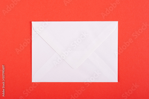 Paper envelope composition on red background. Flat lay.