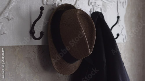 Hanging Up Fedora Hat and Black Coat on a Coatrack Close Up