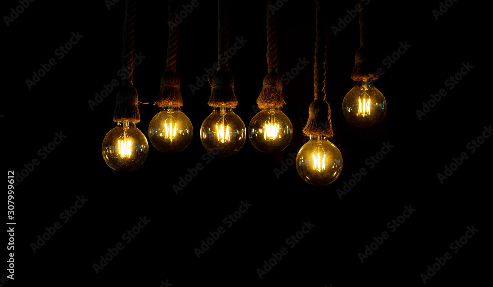 Closeup of light bulb was hung by a rope. isolated on black Closeup of light bulb was hung by a rope. isolated on black