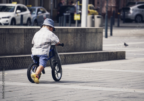 young boy with hat on bike