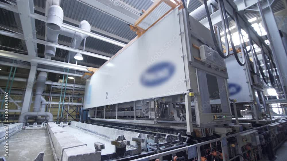 Process of anodizing aluminum plates in production, Immersion of aluminum plates in liquid. Automatic production line in modern manufacture. . Process of anodizing aluminum plates in production, Immersion of aluminum plates in liquid. Automatic production line in modern manufacture. .
