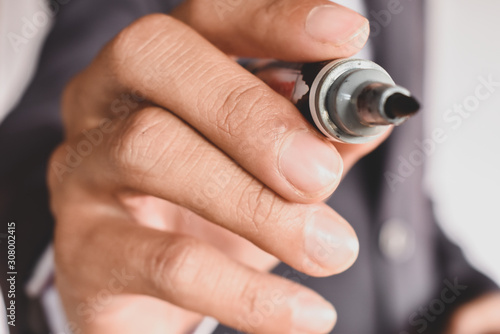 Close Up hand of the businessman is holding a pen