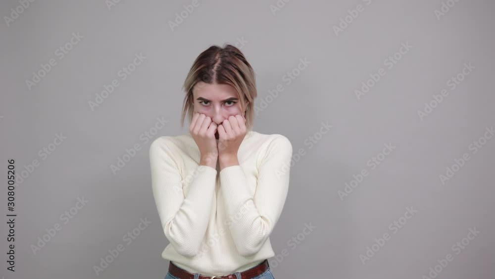 Beautiful and funny young caucasian woman wearing white sweater over isolated gray background suffering pain on hands and fingers, arthritis inflammation, looking scary Beautiful and funny young caucasian woman wearing white sweater over isolated gray background suffering pain on hands and fingers, arthritis inflammation, looking scary