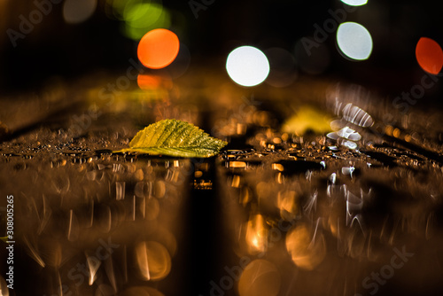Night image of a leaf on a table in the rain