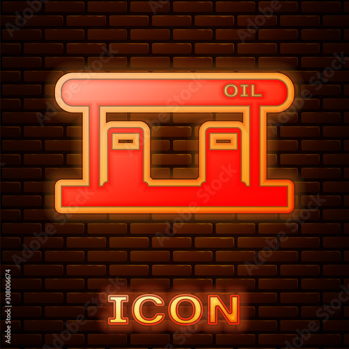 Glowing neon Gas filling station icon isolated on brick wall background. Transport related service building Gasoline and oil station.  Vector Illustration