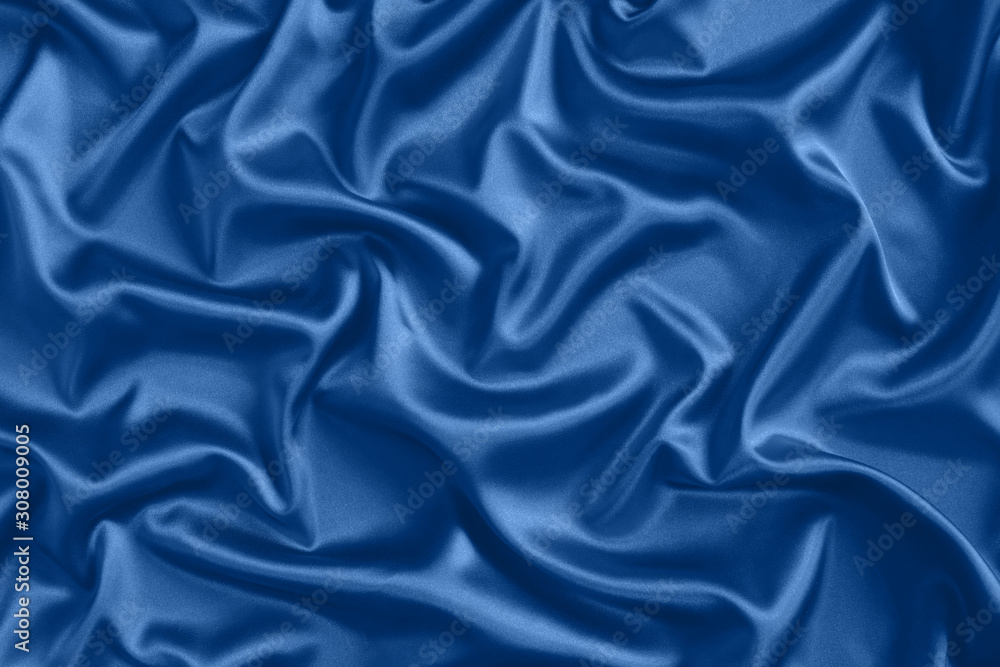 Obraz premium Close up of ripples in blue silk fabric. Satin textile background.