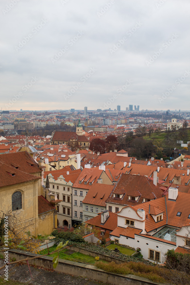 Panorama of the Czech city of Prague with tiled orange roofs from the observation deck of Prague Castle on a cloudy day on the eve of Christmas.
