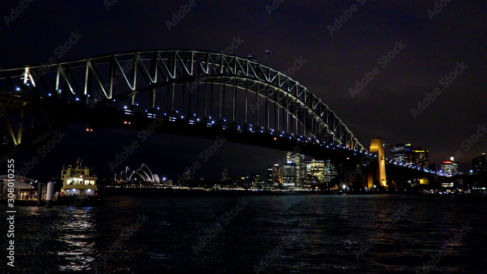 Sydney harbour bridge and city with docked ferry at night