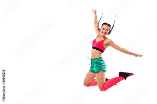 Cheerful young woman jumping and dancing zumba on white background. Copy space.