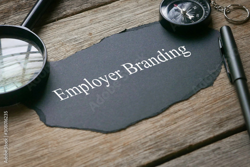 Bilde på lerret Magnifying glass,pen,compass and piece of black paper written with Employer Branding on wooden background
