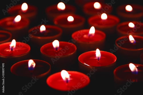 Red candles burning in the dark, close-up.