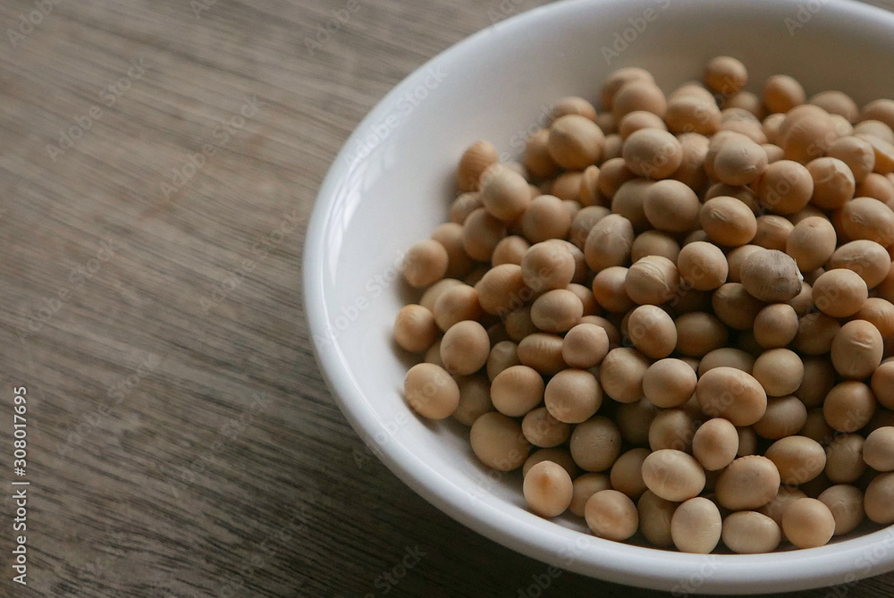 Soybeans in a white plate on wooden background. Soybeans in a white plate on wooden background.