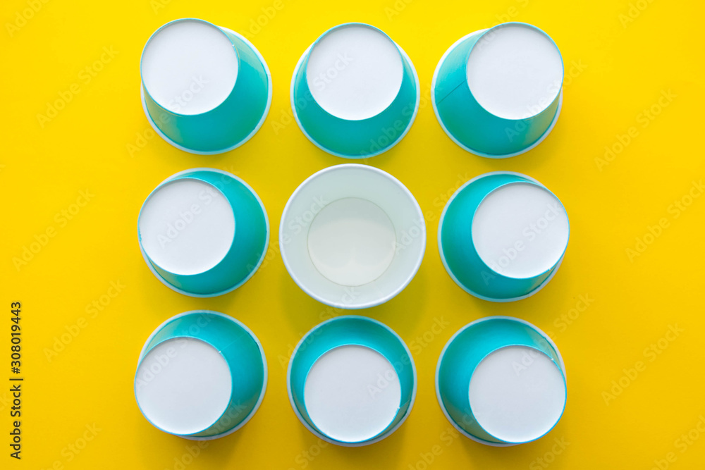 Pattern from blue paper disposable cups on yellow background. Set for party. Top view. Minimalist Style. Copy, empty space for text Pattern from blue paper disposable cups on yellow background. Set for party. Top view. Minimalist Style. Copy, empty space for text