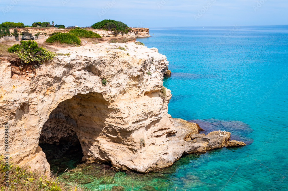Torre Sant Andrea beach with its soft calcareous rocks and cliffs, sea stacks, small coves and the jagged coast landscape. Crystal clear water shape white stone creating natural arcs. Melendugno Italy