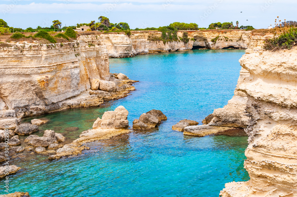 Torre Sant Andrea beach with its soft calcareous rocks and cliffs, sea stacks, small coves and the jagged coast landscape. Crystal clear water shape white stone create natural stacks. Melendugno Italy Torre Sant Andrea beach with its soft calcareous rocks and cliffs, sea stacks, small coves and the jagged coast landscape. Crystal clear water shape white stone create natural stacks. Melendugno Italy