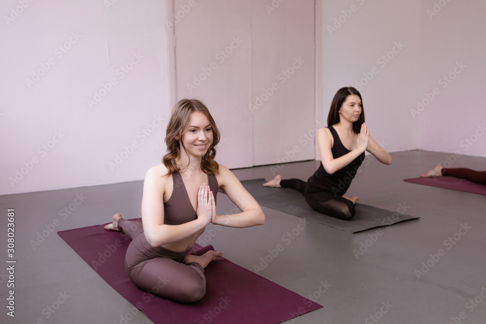 Group of young women sitting and meditating in pose, , yoga lesson concept close-up Group of young women sitting and meditating in pose, , yoga lesson concept close-up